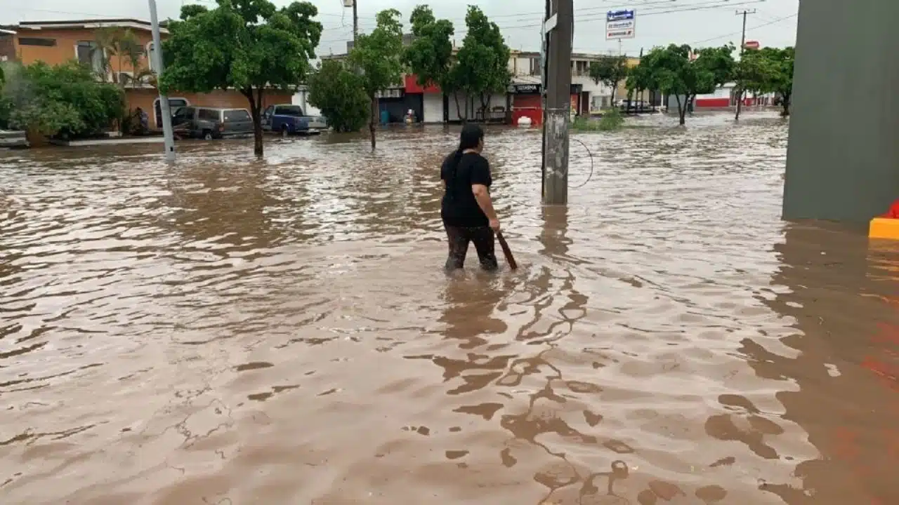 Mujer caminando por una calle inundada