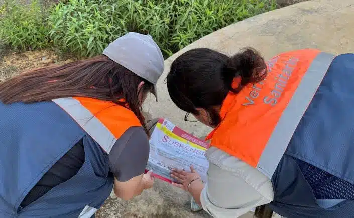 Personal de Coepriss colocando los avisos de suspensión