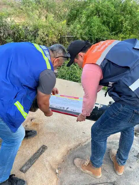 Personal de Coepriss colocando los avisos de suspensión