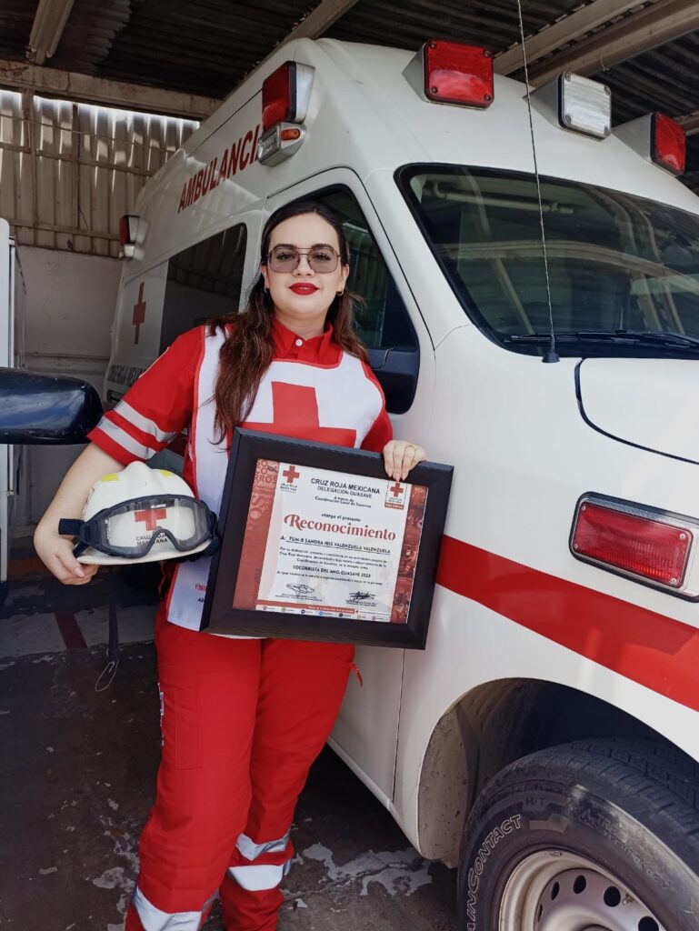 Sandra Iris Valenzuela Valenzuela posando con su reconocimiento de Cruz Roja
