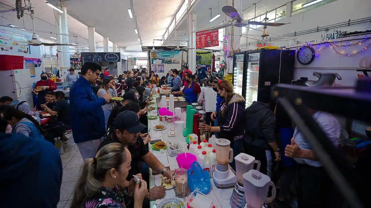 Comerciantes trabajando y atendiendo a comensales que se encuentran consumiendo productos al interior del mercado municipal en Guasave