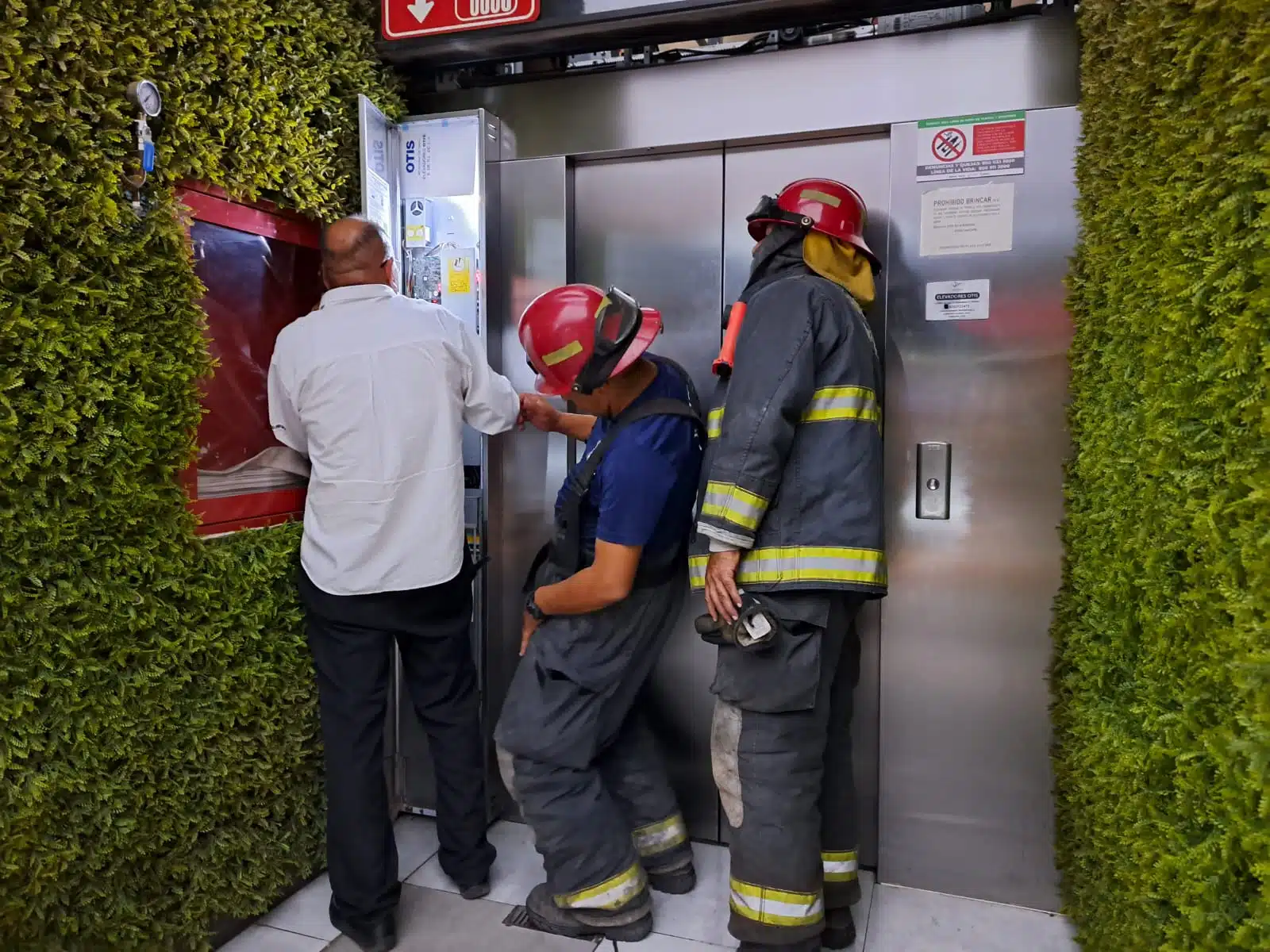 Personal de Bomberos inspeccionando el elevador en donde quedaron atrapados dos adolescentes