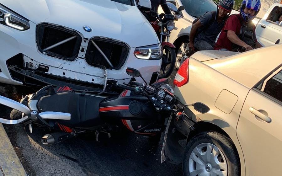 Motocicleta atorada entre dos vehículos