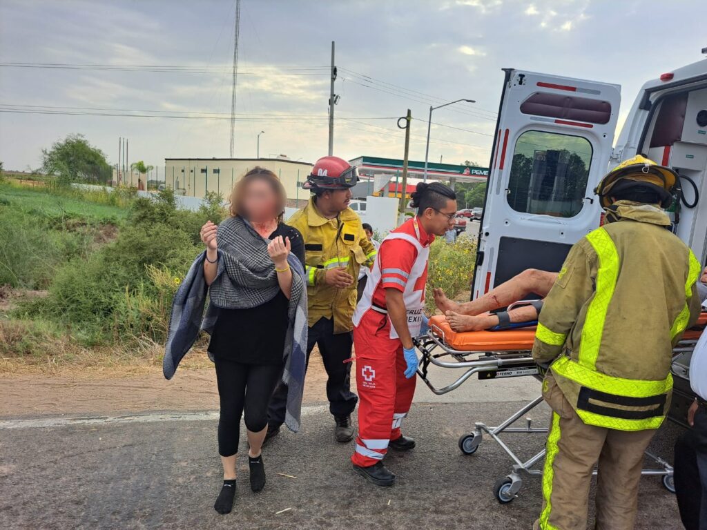 Una joven lesionada, bomberos, paramédicos de Cruz Roja y un joven lesionado sobre la carretera hacía la playa Las Glorias