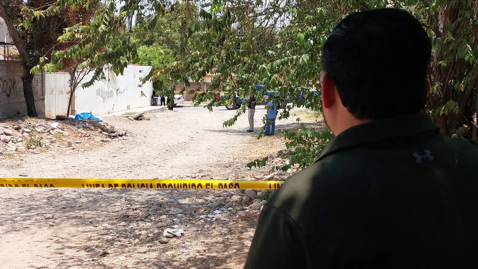 Agente estatal resguarda línea amarilla que delimita hallazgo de un hombre sin vida