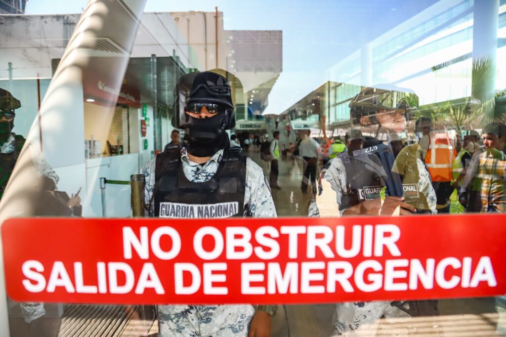 Agentes de la Guardia Nacional detrás del cristal de la puerta del aeropuerto de Culiacán