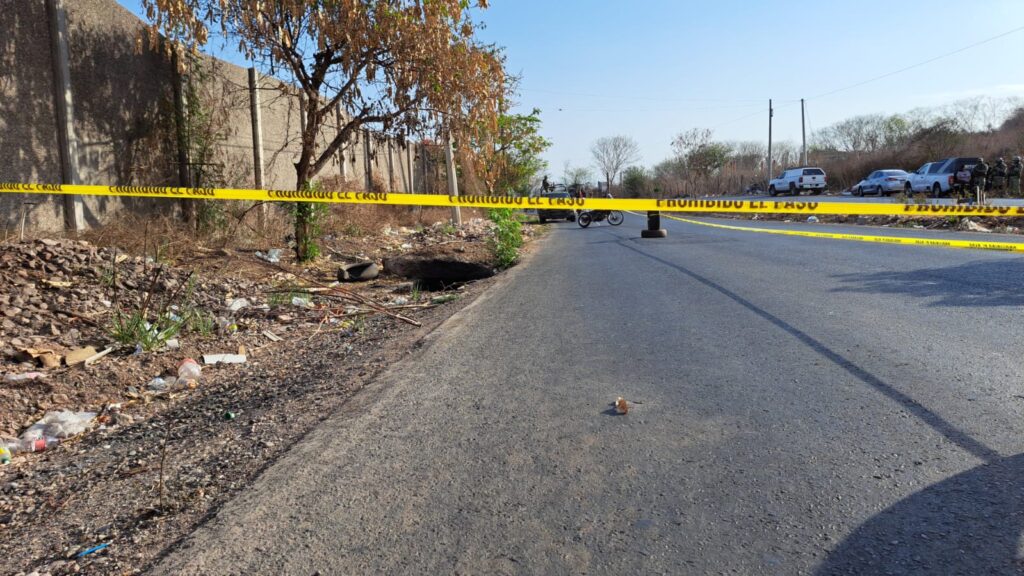 Área de un crimen delimitada con cinta amarilla, el cuerpo de la víctima quedó a un lado de la calle