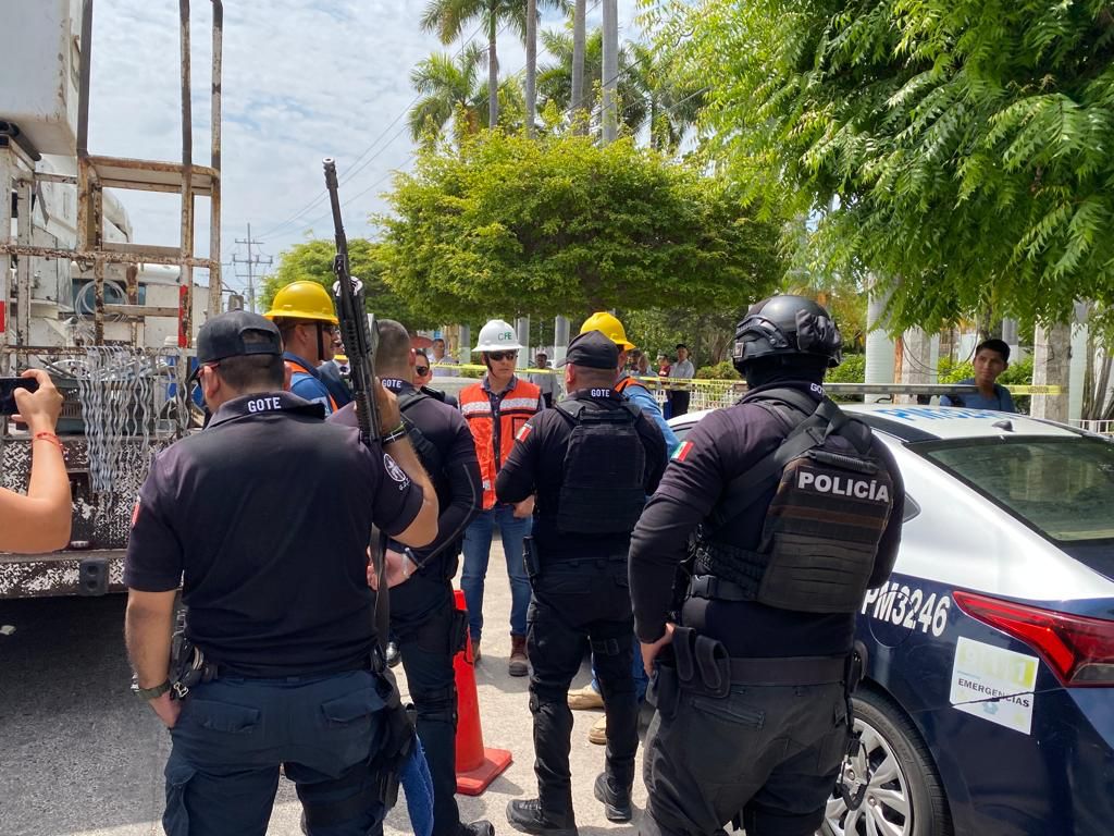 Policías y personal de la CFE platicando a un lado de una patrulla y del camión de la comisión de electricidad