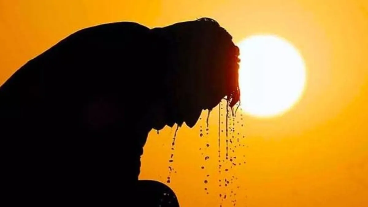 Foto a contraluz de un hombre bañado en sudor o agua y de fondo el sol en una tarde rojiza/anaranjada