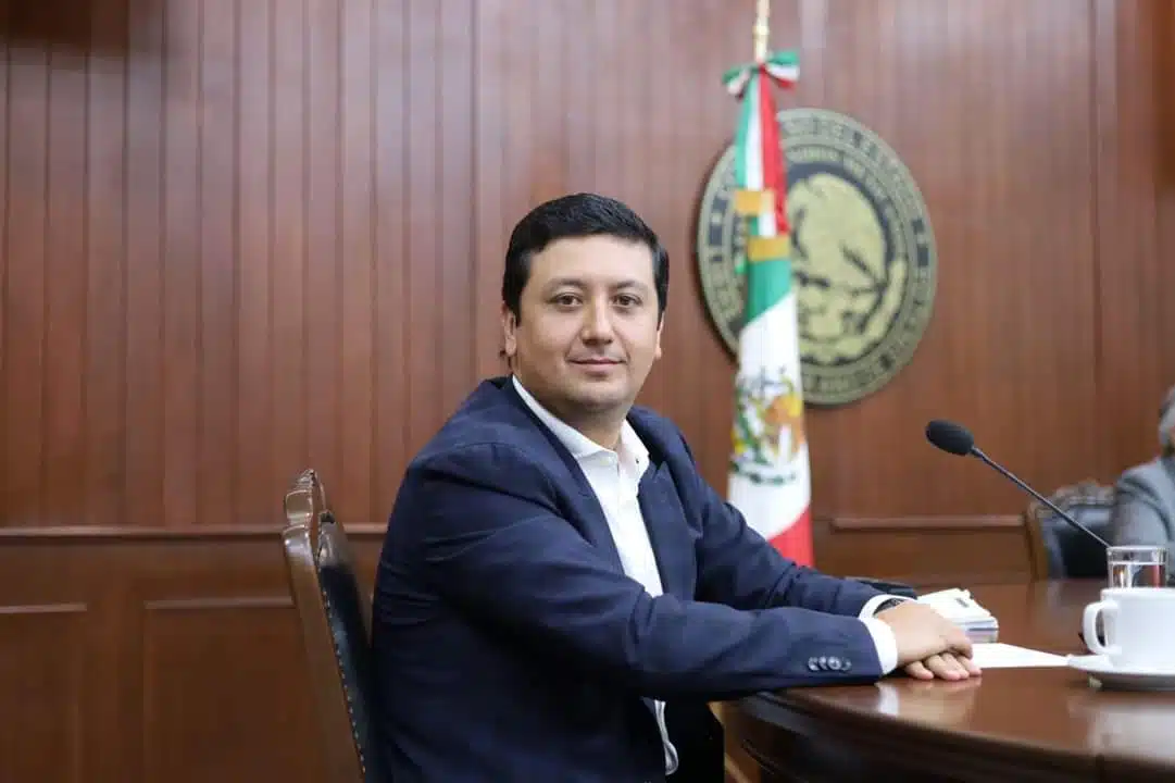 Diputado Feliciano Valle Sandoval en el Congreso del Estado de fondo la bandera de México y el Escudo Nacional