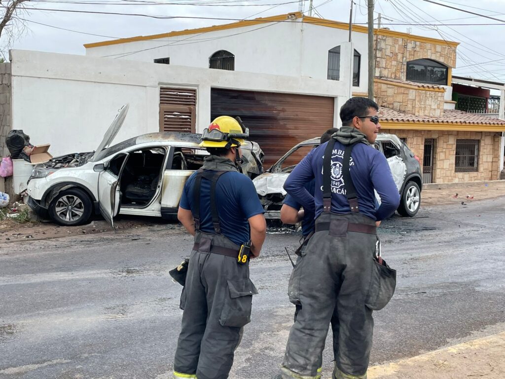 Dos bomberos tras apagar el incendio de dos autos sobre la Culiacancito en Culiacán