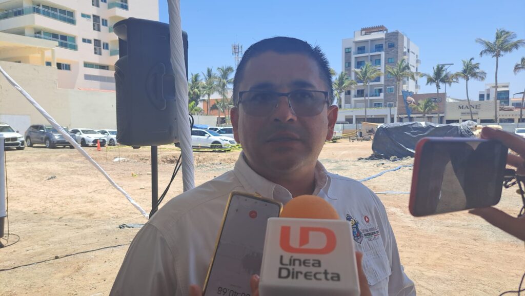 Eloy Ruiz Gastélum hablando en la playa con medios de comunicación