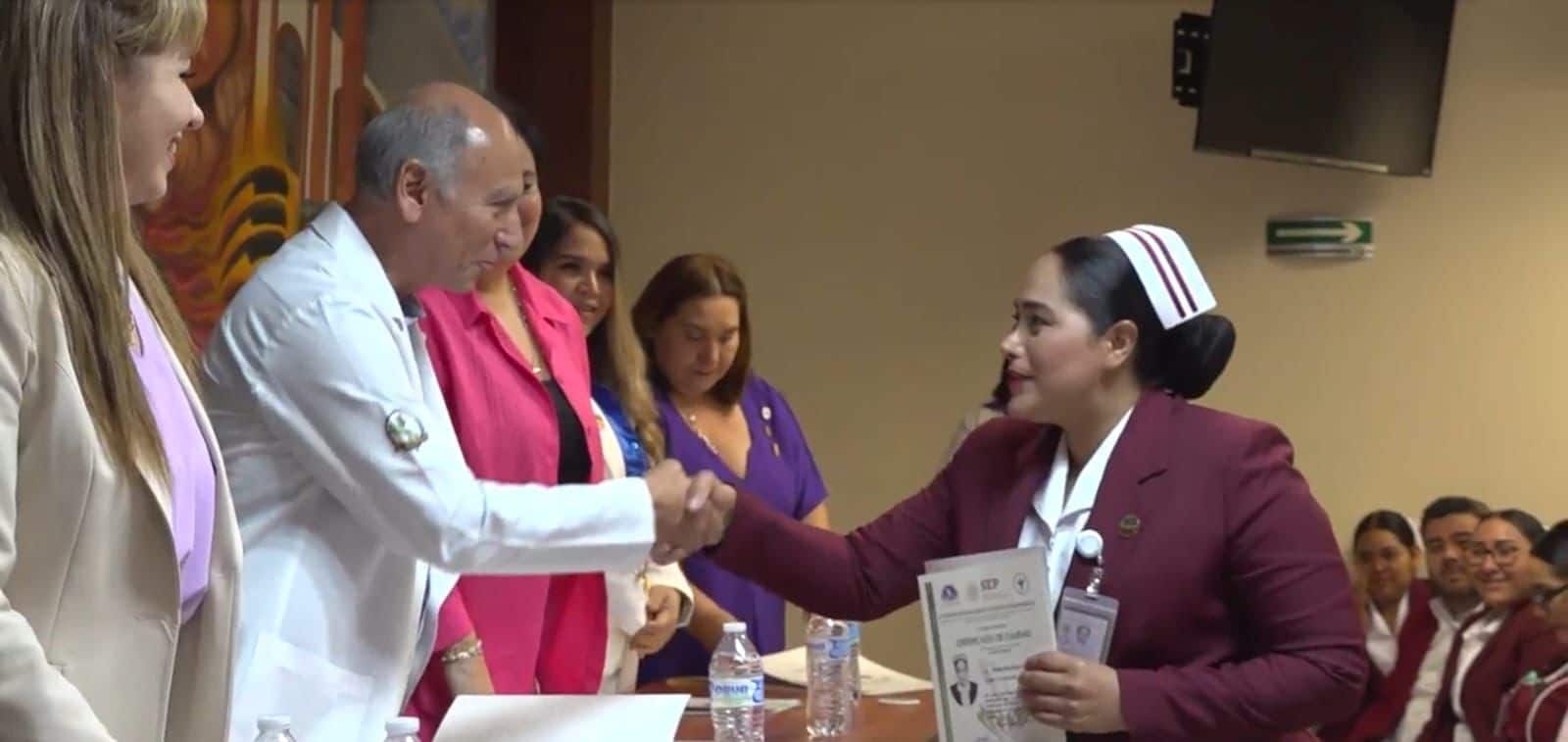 Una persona saludando a otra de mano y recibiendo una carpeta