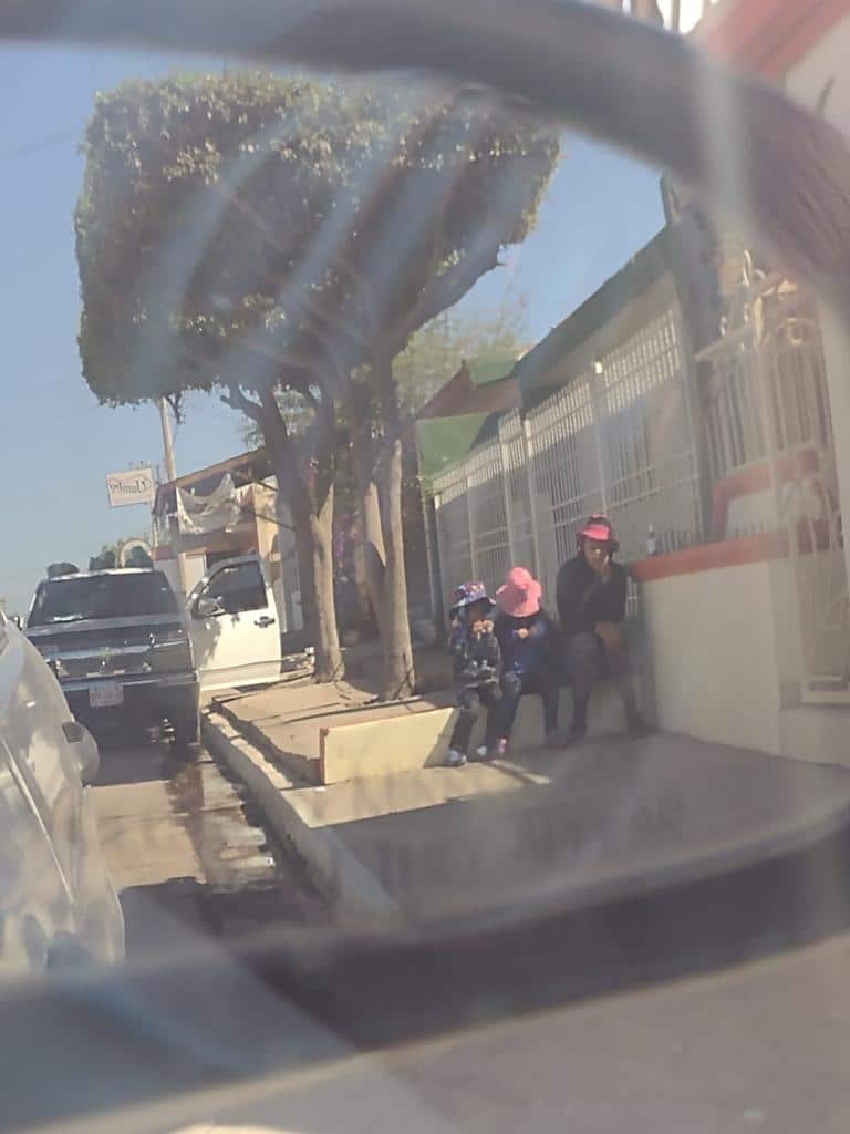 Dos personas y una niña sentada en una baqueta