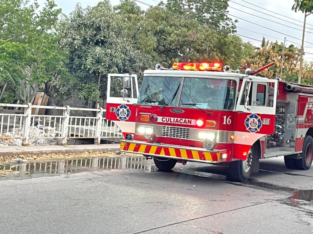 Camión de bomberos con las puertas abiertas estacionado sobre la calle