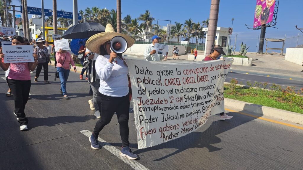 Manifestantes portan mantas y altavoces para exigir ser escuchados y un alto a la impunidad y corrupción en Mazatlán