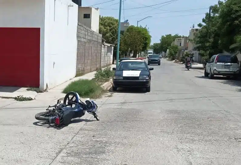 Motocicleta tirada en calle tras choque en Guasave de fondo patrulla de Tránsito