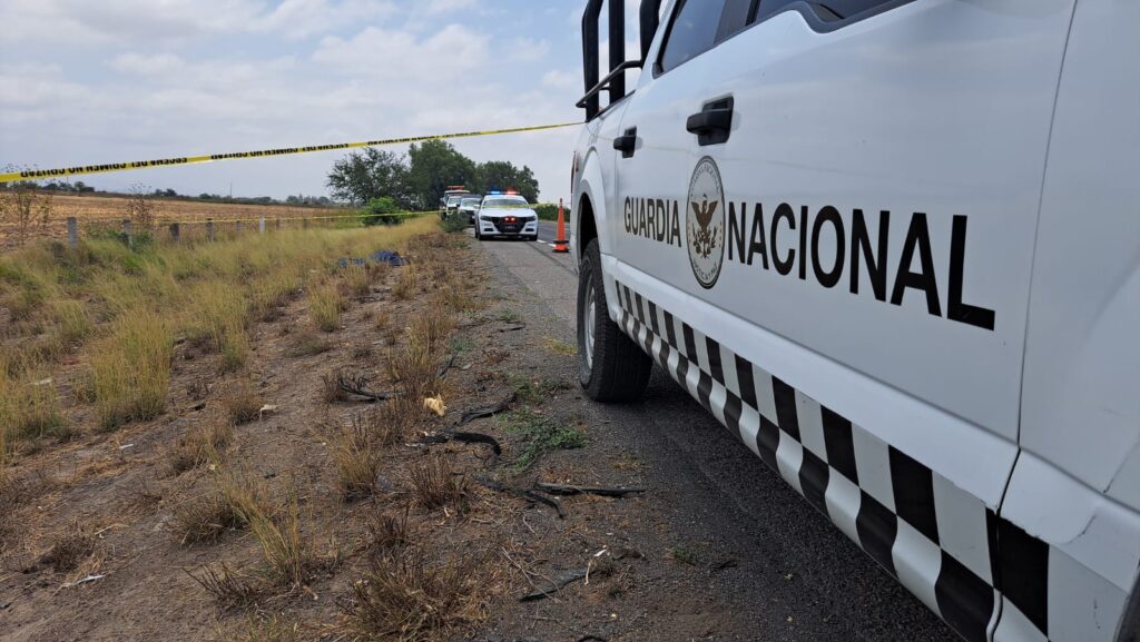 Guardia Nacional a un lado del cuerpo de una mujer sin vida en el acotamiento de la maxipista Culiacán-Mazatlán