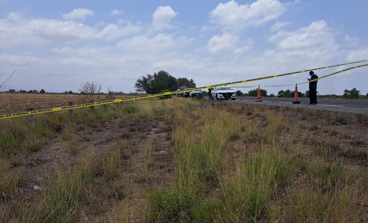 Guardia Nacional a un lado del cuerpo de una mujer sin vida en el acotamiento de la maxipista Culiacán-Mazatlán