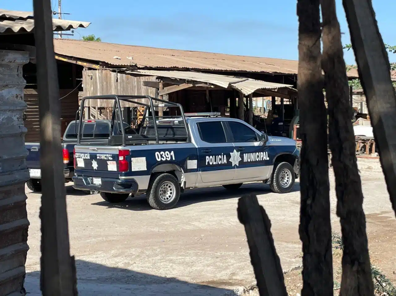 Patrulla de la Policía Municipal de Culiacán en la maderería donde fue encontrado un velador calcinado