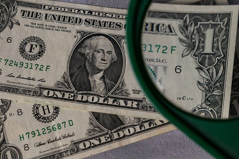 Una lupa y 2 billetes estadounidenses