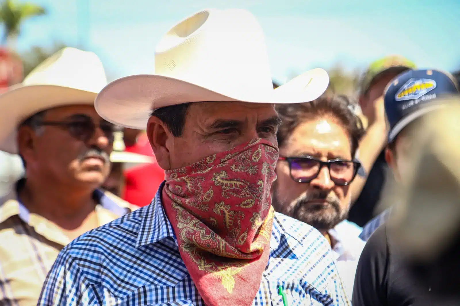 Productores de Sinaloa se cubren los rayos del sol con sombreros en medio de bloqueo a accesos del Aeropuerto Internacional de Culiacán