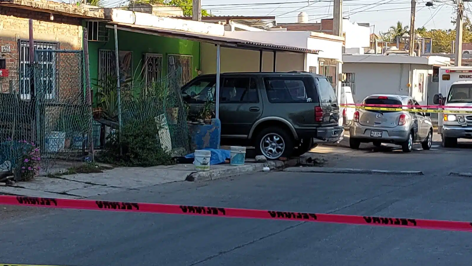 Sobre la banqueta entre botes para la basura quedó el cadáver de un joven que no fue identificado en el lugar este domingo en Mazatlán