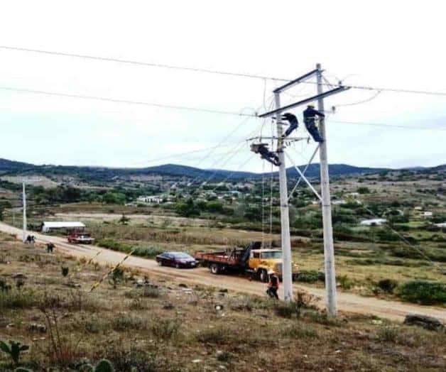 Trabajadores de cfe en un poste