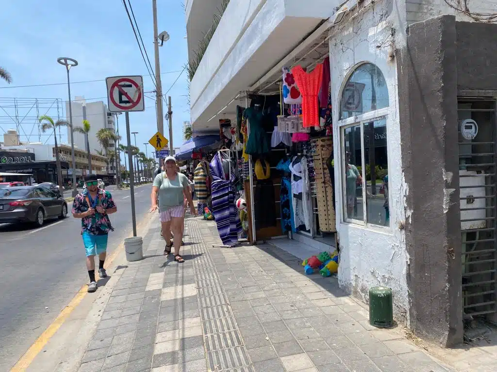 Comercio en Mazatlán donde pasan caminando dos personas