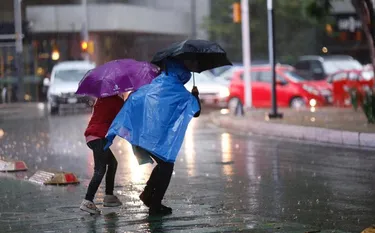 Una persona con paraguas bajo la lluvia