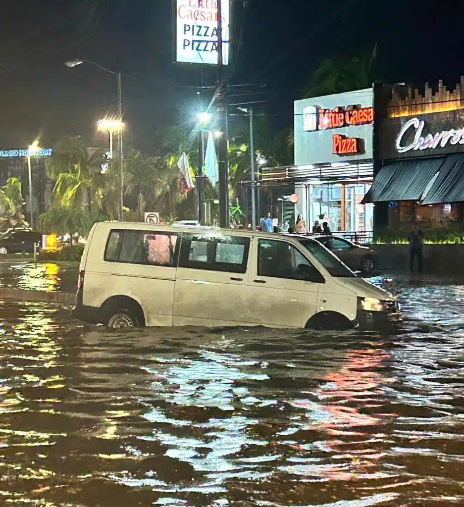 Vehículo circulando por calle inundada