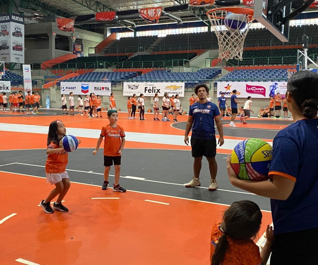 Niños practicando baloncesto durante el campamento de verano de Pioneros de Los Mochis