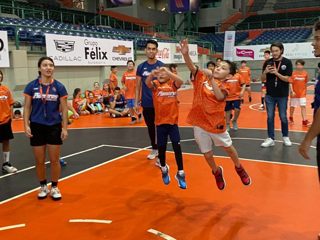 Niños practicando baloncesto durante el campamento de verano de Pioneros de Los Mochis