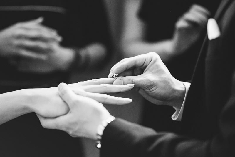 Novio colocándole el anillo a la novia en casamiento