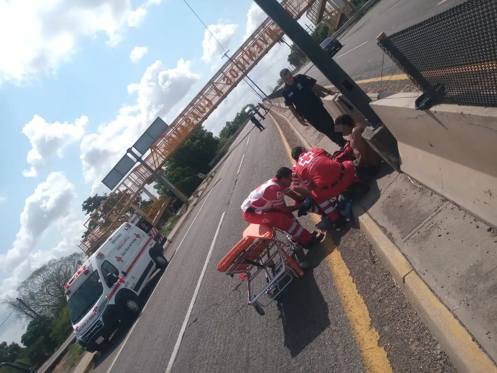Personal de Cruz Roja auxiliando a la persona que fue arrollada en la carretera