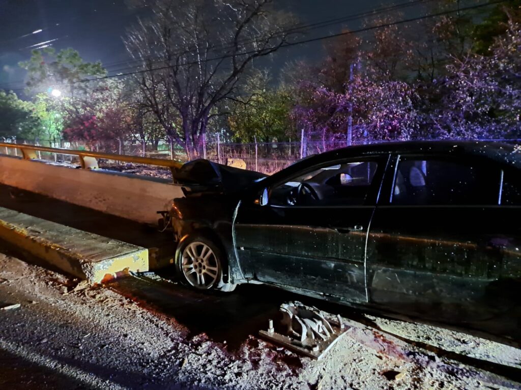 Auto destrozado de la parte delantera, impactado contra un muro de concreto
