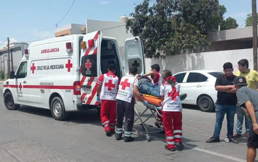 Personal de la Cruz Roja subiendo a la ambulancia a una persona herida de gravedad mientras testigos observan