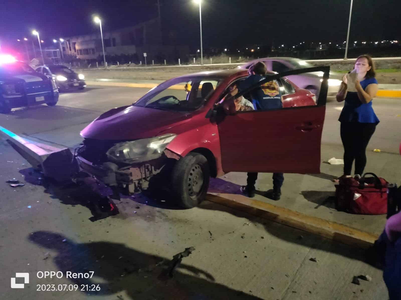 Un carro chocado, 2 más pasado al fondo, una camioneta de la policía, 1 persona tomando foto y otra más platicando con el conductor