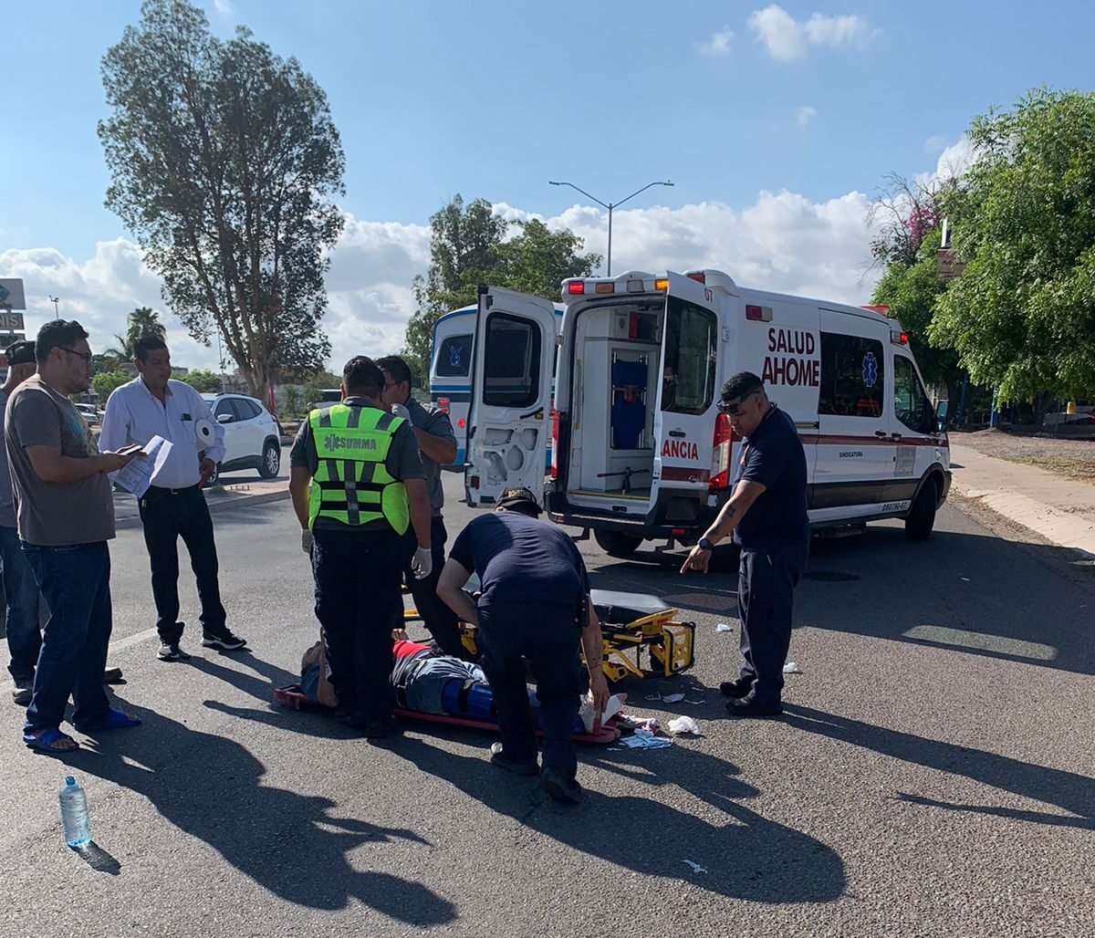 Ambulancia al fondo. Paramédicos dando atención a lesionados de accidente