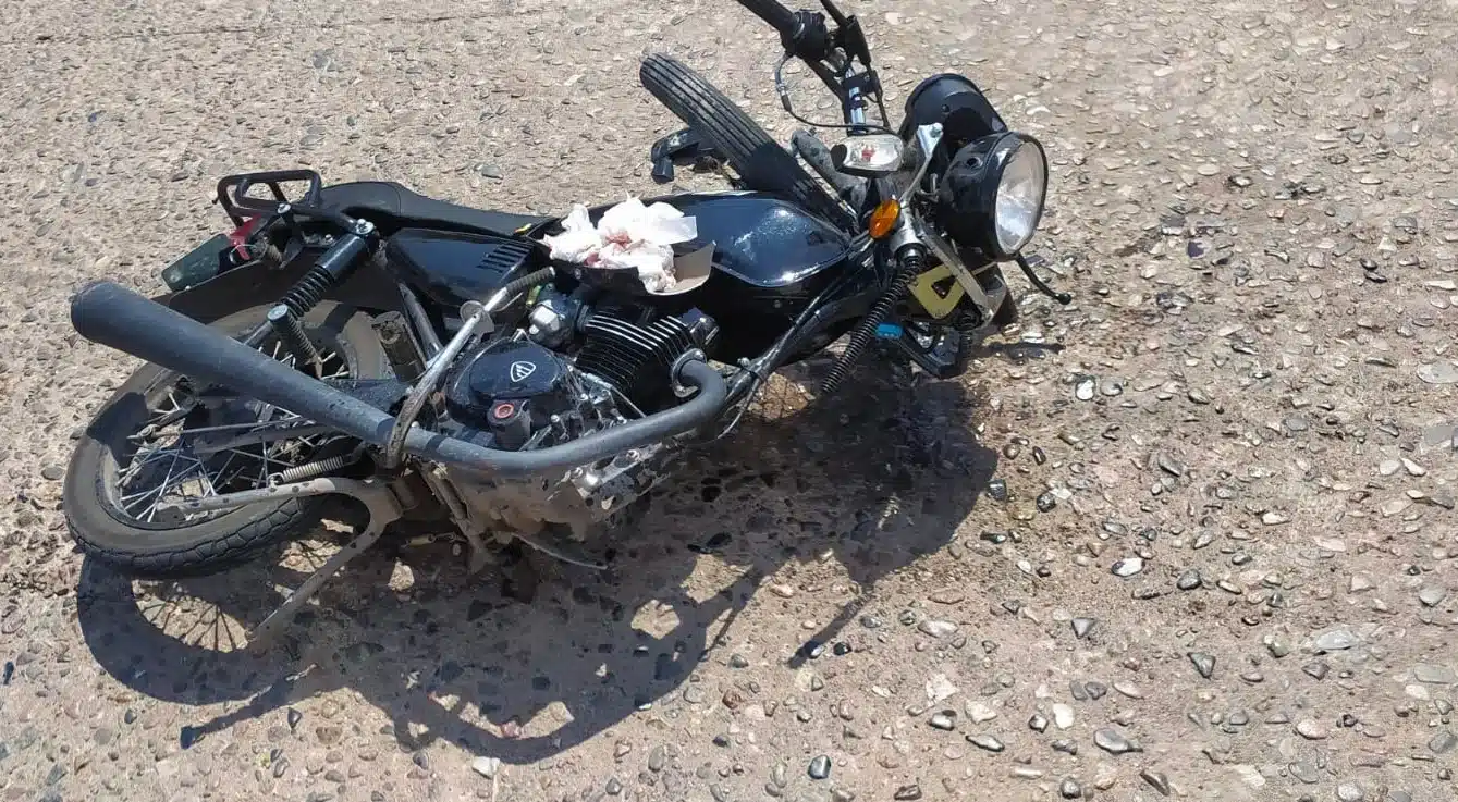 Una motocicleta tiranda en el pavimento, rollo de papel usado arriba de ella