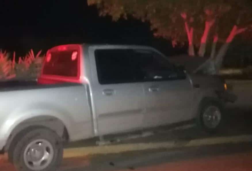 Camioneta color gris tras un árbol tras chocar