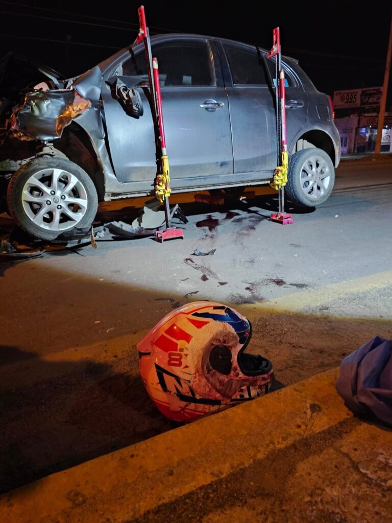 Auto March destrozado tras accidente y un casco de motociclista por un lado