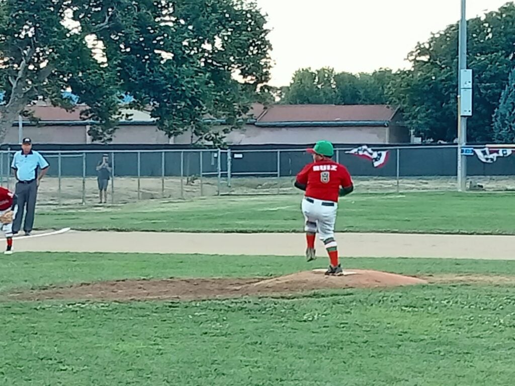 Un niño en la lomita de una cancha de beisbol