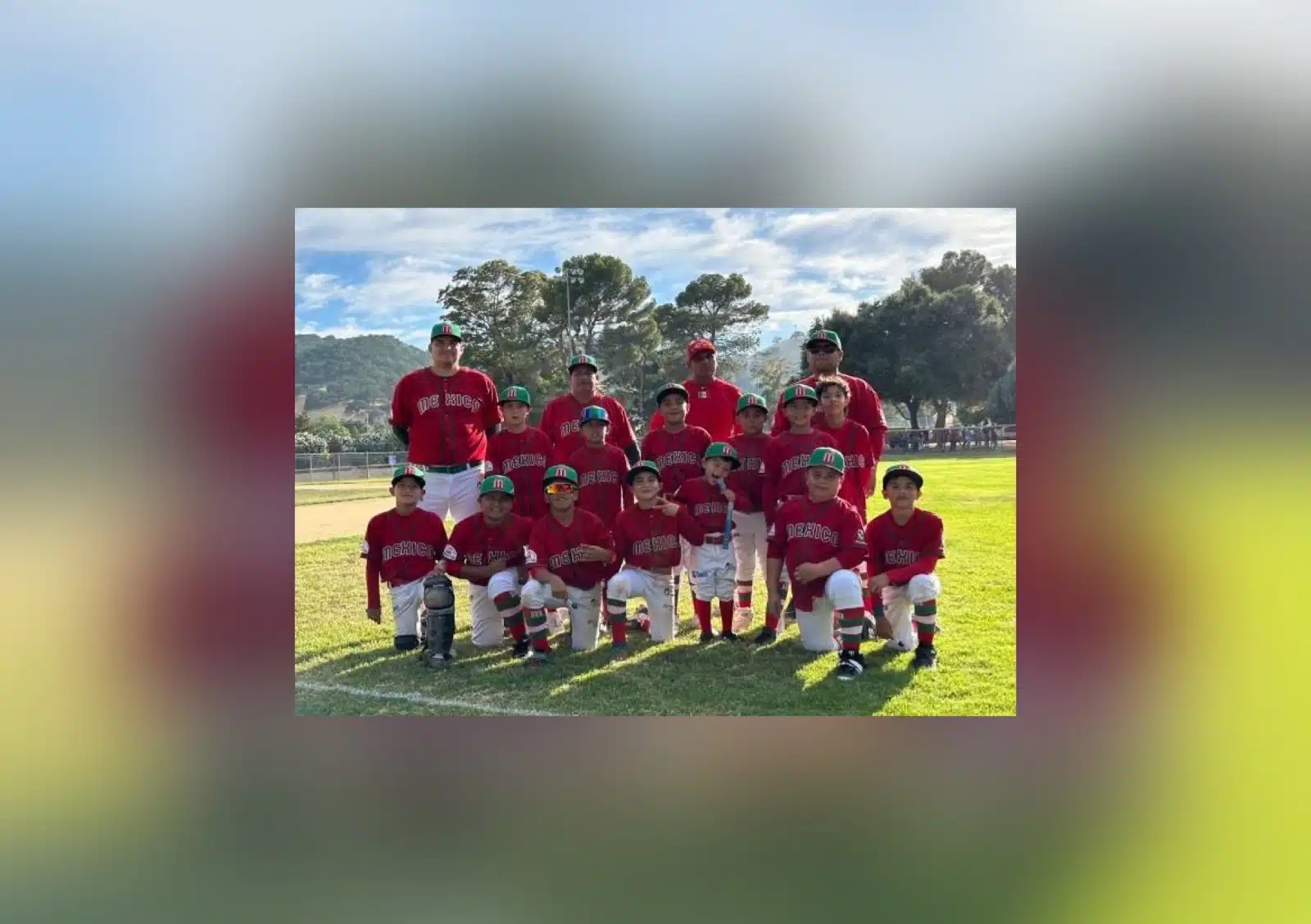 Niños y señores posando para una foto en una cancha con césped