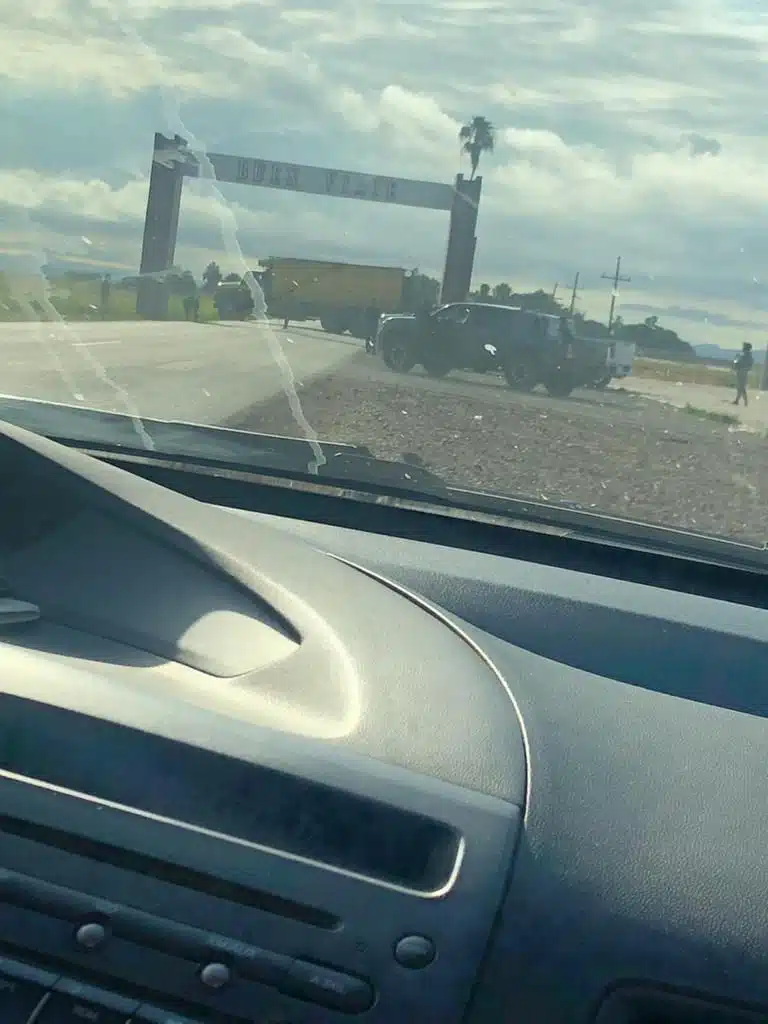 Tráiler bloqueando la carretera y camionetas en la terracería