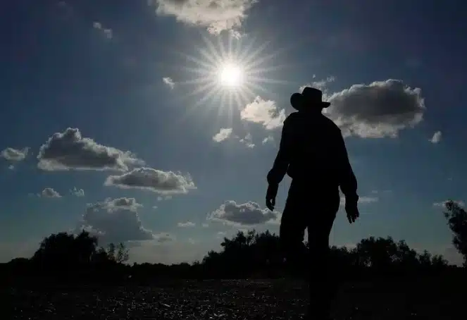 Una persona bajo el sol y un cielo con nubes