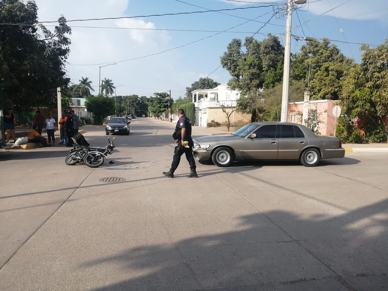 Motocicleta en el suelo tras choque con un auto