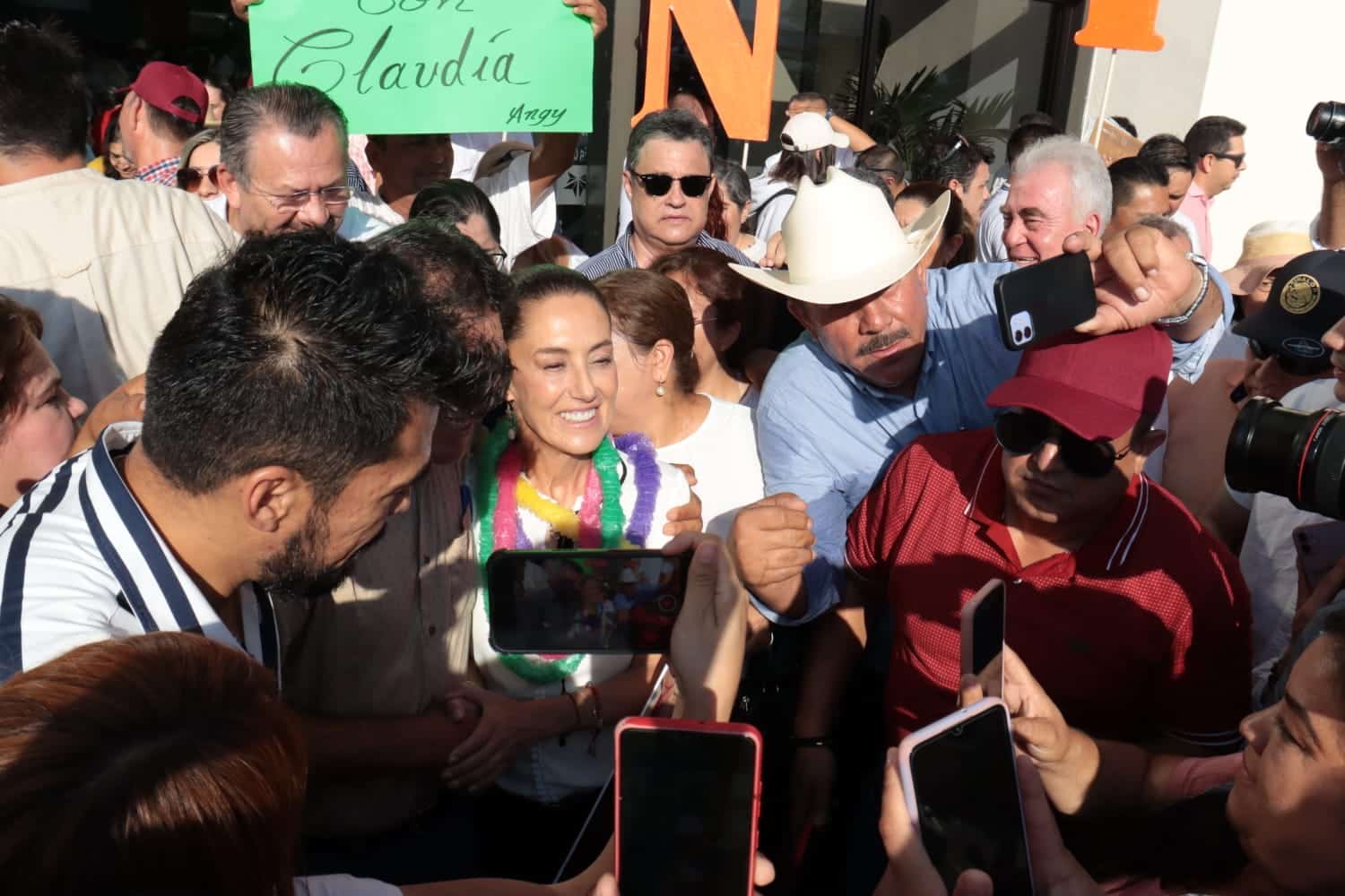Personas, pancartas, cámaras y celulares
