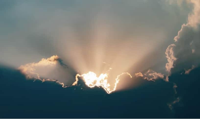 Cielo con nubes y el sol entre ellas saliendo sus rayos