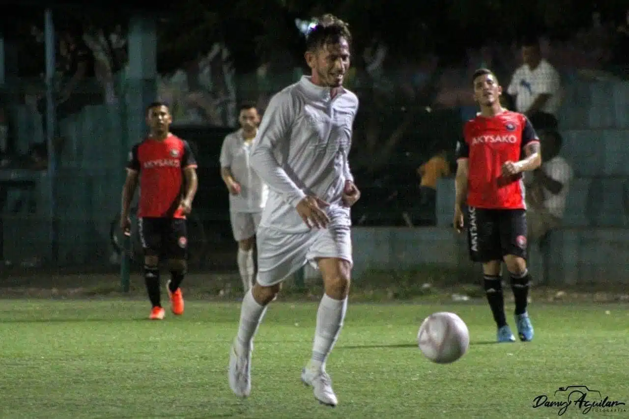 4 personas en una cancha de futbol, césped y un balón